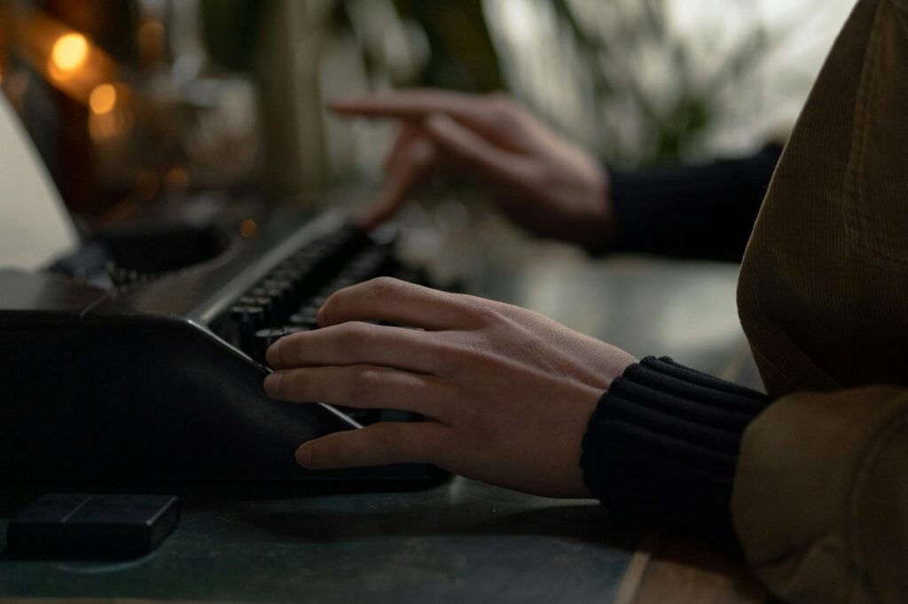 A woman's hands typing on a mechanical typewriter